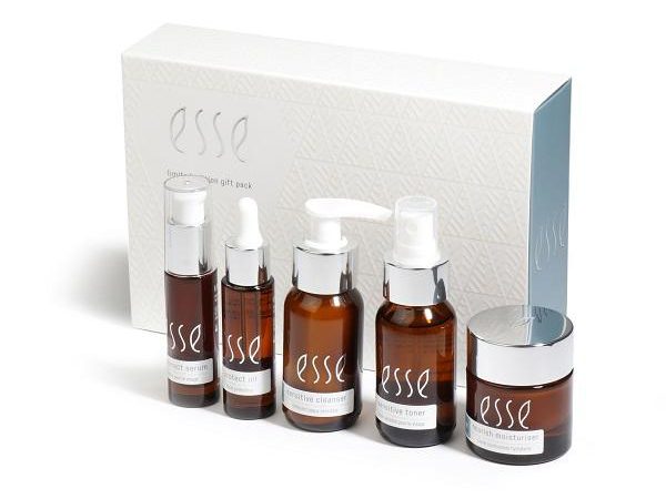 A skincare gift pack featuring five items in brown bottles with white labels that read "esse." The set includes a serum, an extract oil, a gentle cleanser, a sensitive toner, and a rich moisturizer, all placed in front of a white patterned box with the "esse" logo.