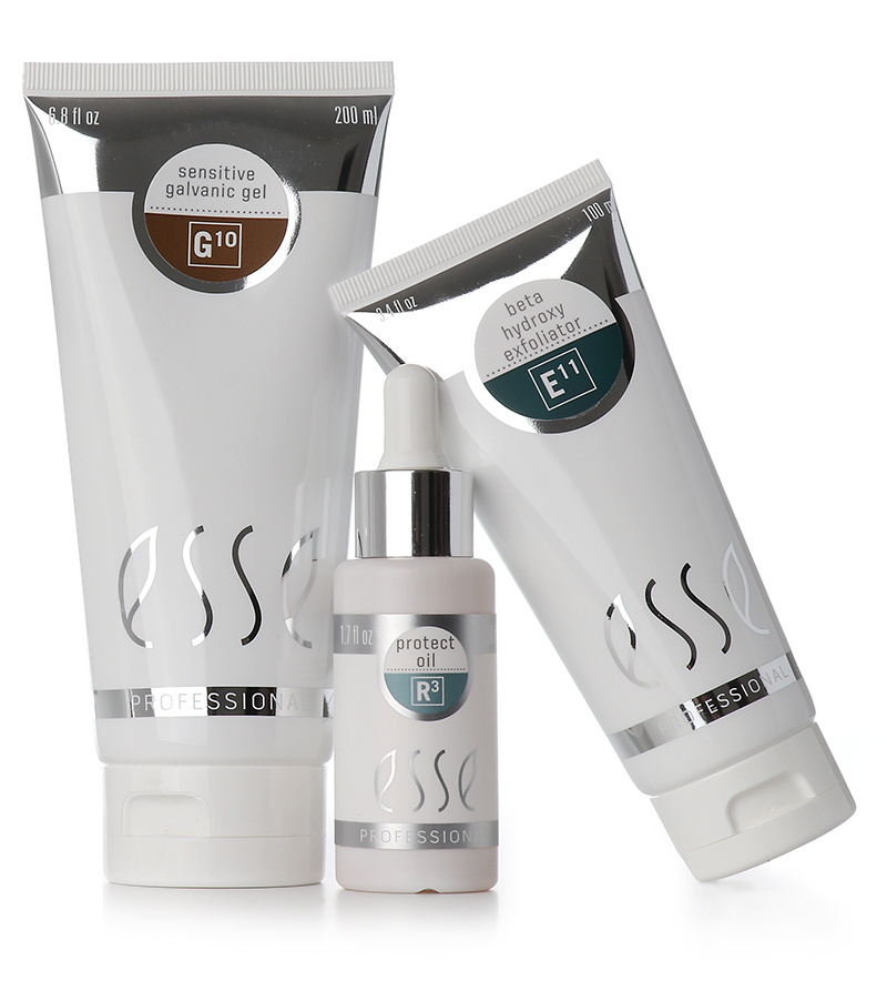 Three skincare products in white packaging with silver accents are shown. From left to right: Sensitive Galvanic Gel (G-10) in a 200 ml tube, Protect Oil (R-1) in a 30 ml dropper bottle, and Beta Hydroxy Exfoliator (E-11) in a 100 ml tube.